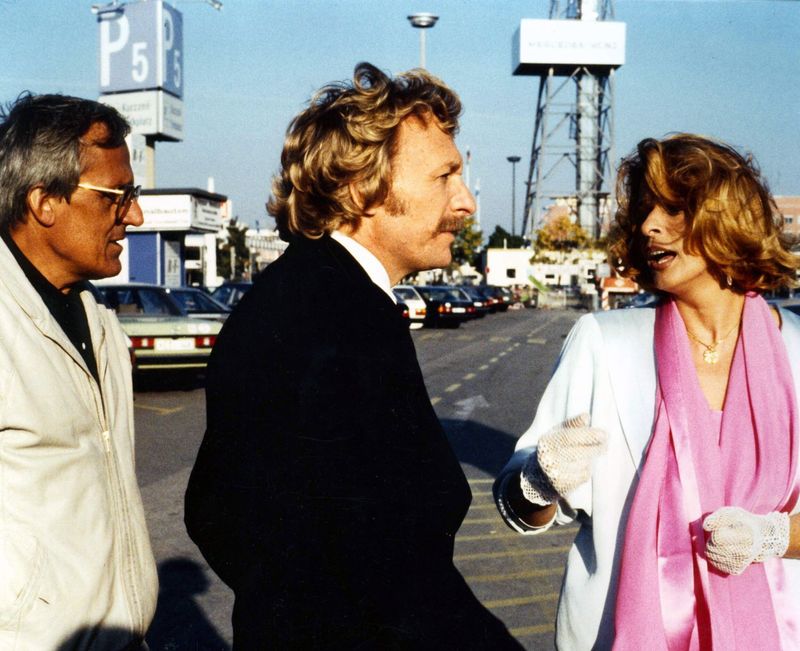 Herbie (Dieter Hildebandt, links) und Baby (Franz Xaver Kroetz) holen Babys Freundin Mona (Senta Berger) vom Flughafen ab. Leider stehen die beiden so unter Stress, dass der Empfang gründlich daneben geht.