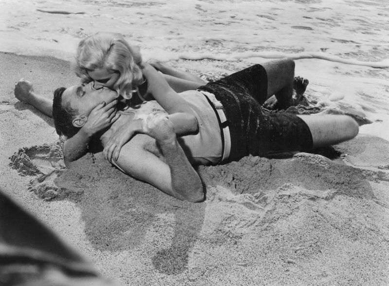 Küssen muss nicht zwingend eine todernste Angelegenheit sein - es geht auch mit Humor. Vor allem, wenn Komödienspezialist Billy Wilder im Spiel ist. Dolores Rosedales und Tom Ewells passionierter Nahkampf im Sand ist eine Parodie auf eine andere berühmte Kussszene der Filmgeschichte: die aus dem Militärdrama "Verdammt in alle Ewigkeit" (1953).