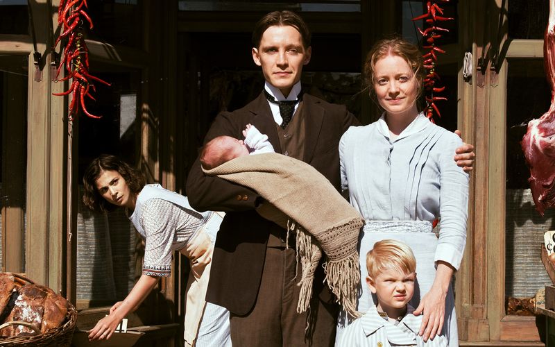 Fidelis Waldvogel (Jonas Nay) und seine Frau Eva (Leonie Benesch, rechts) lassen sich mit ihrem Nachwuchs ablichten. Mit Delphine (Aylin Tezel) arbeitet eine weitere Deutsche in der Wildwest-Metzgerei der ausgewanderten Schwaben.