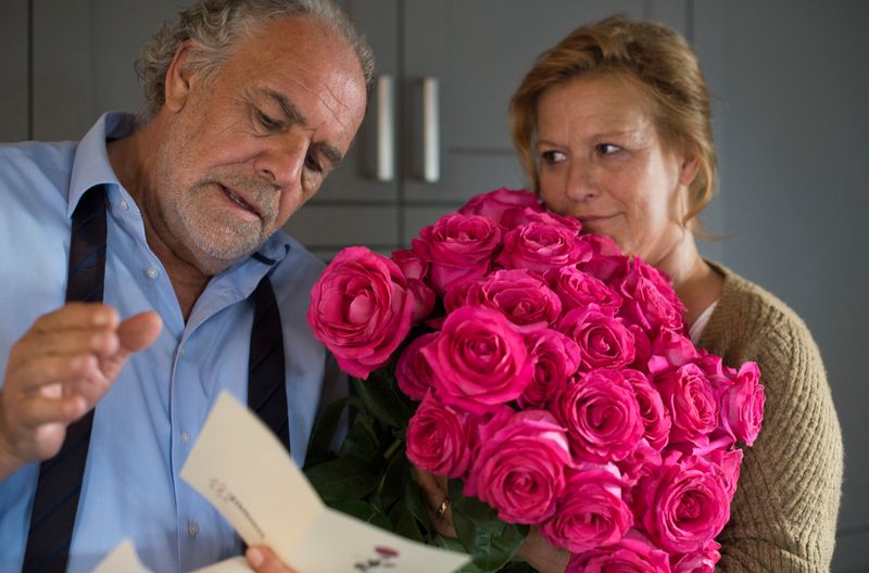 Georg (Christian Kohlund) wundert sich darüber, wer seiner Frau Christine (Suzanne von Borsody) diesen üppigen Strauß Rosen geschickt haben könnte. 