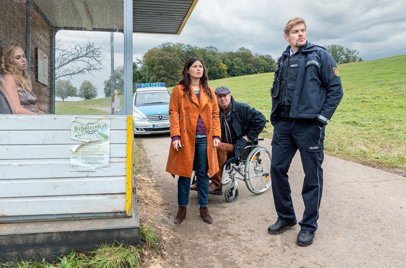Viermal fuhr der Bus an ihr vorbei: Eine Tote sitzt an der Bushaltestelle. Lisa (Anna Fischer) und ihr Vater Alfons (Artus Maria Matthiesen, zweiter von rechts) wollen wissen, um wen es sich handelt. Der Polizist Andi Kuhn (Helgi Schmid) zeigt sich eher desinteressiert.