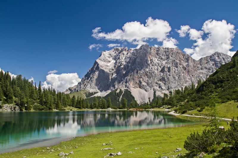 Die Zugspitze ist mit einer Höhe von 2.962 Metern der höchste Berg Deutschlands. Majestätisch und erhaben thront sie im Wettersteingebirge an der Grenze zu Tirol. Bequem zu erreichen ist der Gipfel über eine Bahnfahrt vom Wintersportort Garmisch-Partenkirchen aus. Die Wanderung auf die Zugspitze dauert in etwa einen Tag. 
