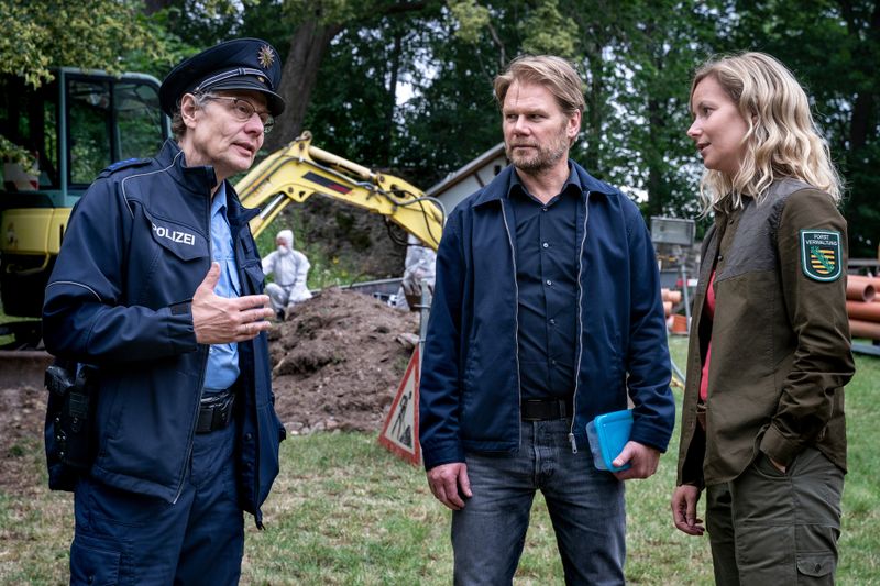 Ortspolizist Rainer Wagner (Thomas Bading) unterrichtet Kommissar Robert Winkler (Kai Scheve) und die Erzgebirgsförsterin Saskia Bergelt (Teresa Weißbach) über den Leichenfund im Schatten der Burg Hartenstein.