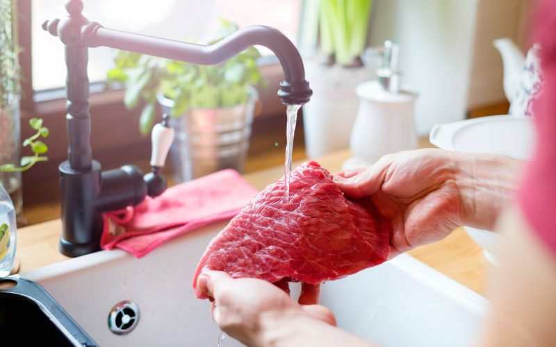 Viele reinigen Fleisch vor dem Kochen unterm Wasserstrahl. Denn Fleisch wird oft als Quelle für Bakterien und Keime gesehen und wird deshalb zusätzlich gewaschen, bevor das Brathuhn im Ofen oder das Steak in der Pfanne landet. Doch hygienisch ist diese Praxis auf keinen Fall. Denn Bakterien brauchen Wasser zum Wachstum und vermehren sich womöglich, wenn Fleisch gewaschen wird.