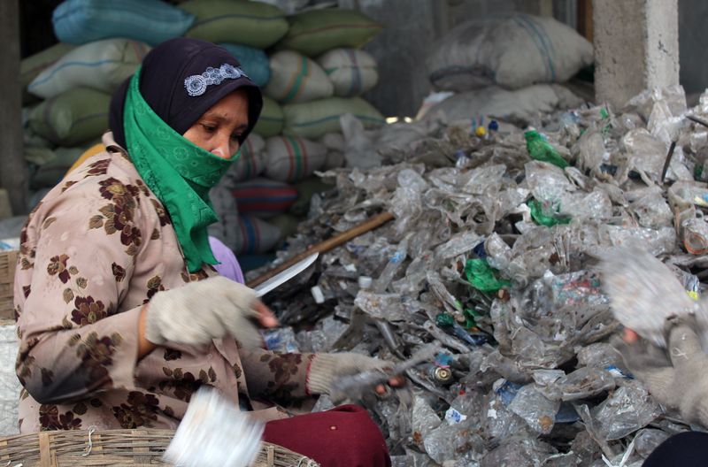 Eine Frau sammelt Müll in den Müllbergen von Bangun, Indonesien.