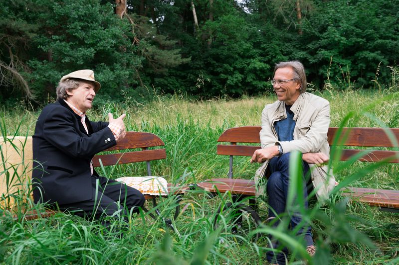 Erwin Pelzig und der Kulturkritiker Harald Welzer einsam im Gras auf Pelzigs mitgebrachten Bänken. Da heißt es: Antworten oder die verhasste Bowle trinken!