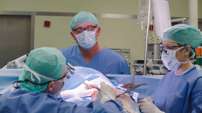 Schauspieler Hans Sigl (Mitte) beobachtet Herzchirurg Prof. Johannes Albes und seine Assistenzärztin Dr. Roya Ostovar bei der Arbeit.