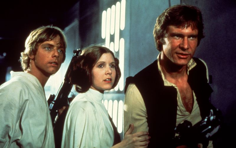 Luke (Mark Hamill, links), Prinzessin Leia (Carrie Fisher, Mitte) und Han Solo (Harrison Ford) versuchen, Darth Vader und seinen Schergen zu entkommen.