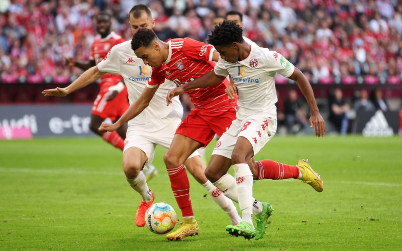Die Mainzer (hier Leandro Barreiro) wollen den FC Bayern um Mittelfeld-Juwel Jamal Musiala (Mitte) im Pokal zum Straucheln bringen.