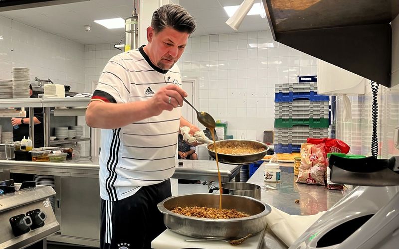 Tim Mälzer muss im Quartier der deutschen Nationalmannschaft Sucuk-Pasta und einen Protein-Kuchen möglichst originalgetreu nachkochen.