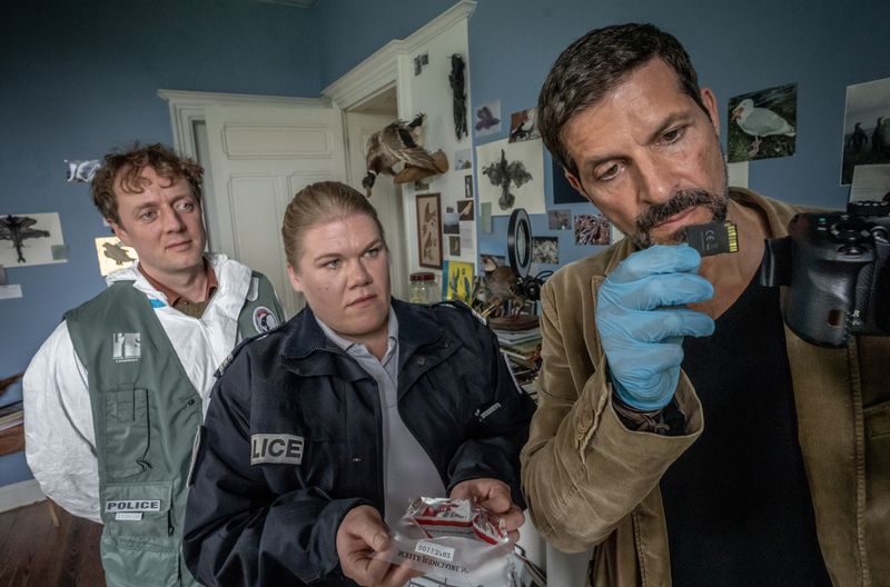 Kommissar Dupin (Pasquale Aleardi, rechts), Forensiker Frack (Jesse Albert) und Polizistin Nevou (Gisa Flake) untersuchen ein Zimmer der ermordeten Witwe Joelle, einer Vogelliebhaberin. 

