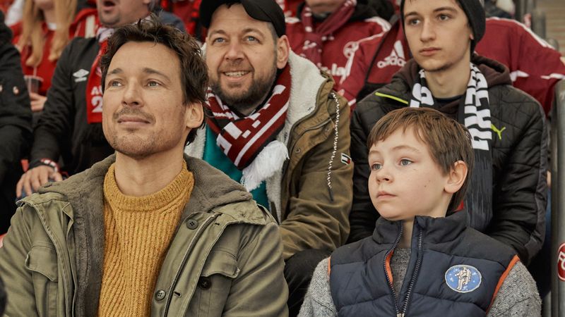 Mirco (Florian David Fitz, links) und Jason (Cecilio Andresen) sind die "Wochenendrebellen". Um einen Lieblingsverein für Jason zu finden, wollen sie die verschiedenen deutschen Profi-Fußballvereine genau unter die Lupe nehmen. Alle 56, live im Stadion ...