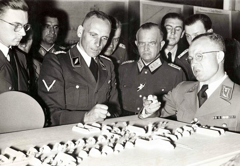 Der Agrarökonom Dr. Konrad Meyer (rechts) vor einem Dorfmodell der Ausstellung "Planung und Aufbau im Osten",1941. Mithilfe von Wissenschaftlern wurde die Umsetzung der Rassenideologie vorgeplant.