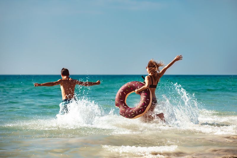 Im Meer schwimmen oder einfach am Strand in der Sonne liegen - im Urlaub soll es entspannt zugehen. Damit sich alle wohlfühlen, sollte man ein paar Regeln beachten. Was ist am Strand angemessen zu tragen? Wie laut darf Musik sein? Die Antworten darauf sind je nach Land und Region unterschiedlich. Wir verraten Ihnen die wichtigsten Benimmregeln für einen entspannten Tag am Strand.