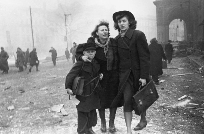 Zwei Frauen und ein Junge vor den Trümmern am Anhalter Bahnhof in Berlin nach einem Luftangriff im Februar 1945. Etwa 600.000 deutsche Zivilisten kamen im Zweiten Weltkrieg durch alliierte Luftangriffe ums Leben.