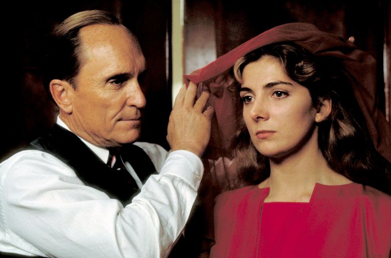Kommandant Fred (Robert Duvall) ist gespannt auf die "Zusammenarbeit" mit "Offred" (Natasha Richardson), die ihm und seiner Frau als Gebärmaschine dienen soll. Volker Schlöndorffs Erstverfilmung von Margaret Atwood Roman blieb weniger im Gedächtnis als die preisgekrönte TV-Serie (2017-2025), die fast parallel bei Magenta TV ihren Abschluss findet.