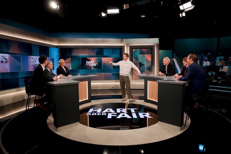 Louis Klamroth (Mitte) begrüßte (von links nach rechts) ARD-Reporter Vassili Golod, Nordrhein-Westfalens Innenminister Herbert Reul (CDU), die saarländische Ministerpräsidentin Anke Rehlinger (SPD), Linken-Chef Jan van Aken, Wirtschaftsexpertin Veronika Grimm und den Journalisten Michael Bröcker im Studio.