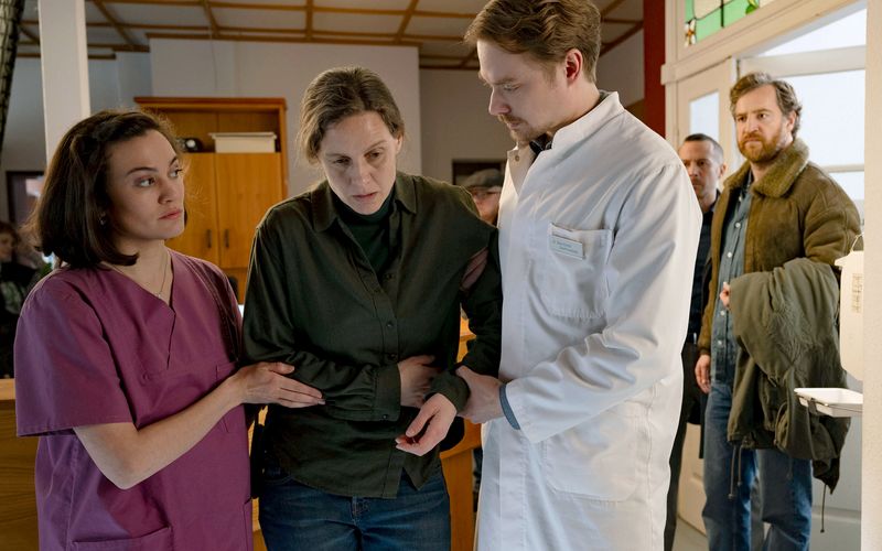 Als Ann Kathrin Klaasen (Picco von Groote, Mitte) mit heftigen Bauchschmerzen beinahe zusammenbricht, bringen Rupert (Barnaby Metschurat, zweiter von rechts) und Frank Weller (Tom Radisch, rechts) sie zu Dr. Sommerfeldt (Sven Schelker, mit Milena Straube). 