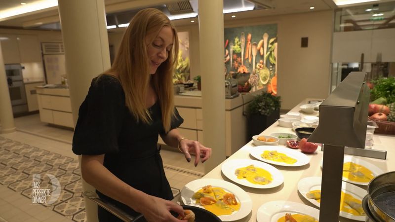 Katharina richtet Ravioli, Garnelen und Safransoße an.
