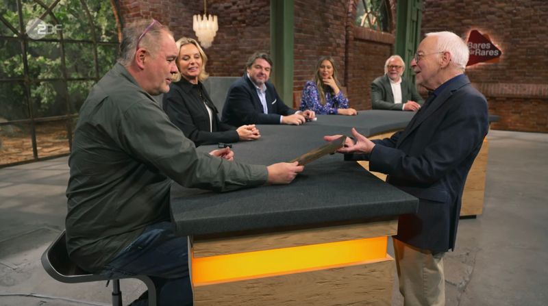 "Das ist eine Überraschung für Waldi", rief der Verkäufer und lief schnurstracks auf Walter Lehnertz zu. "Alter Schwede, das sieht aber cool aus", lautete die Reaktion des Händlers, der sich das Bild mit "dem bildhübschen Mädel" erst mal genauer ansehen wollte. Eine Kandidatin für sein Erotikzimmer? Jedenfalls startete "Waldi" mit 480 Euro. 