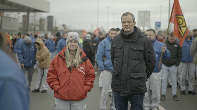 ZDF-Wirtschaftsexperte Florian Neuhann (vorne rechts) trifft Beschäftigte der Autowerke, die sich auf Arbeitskämpfe vorbereiten.