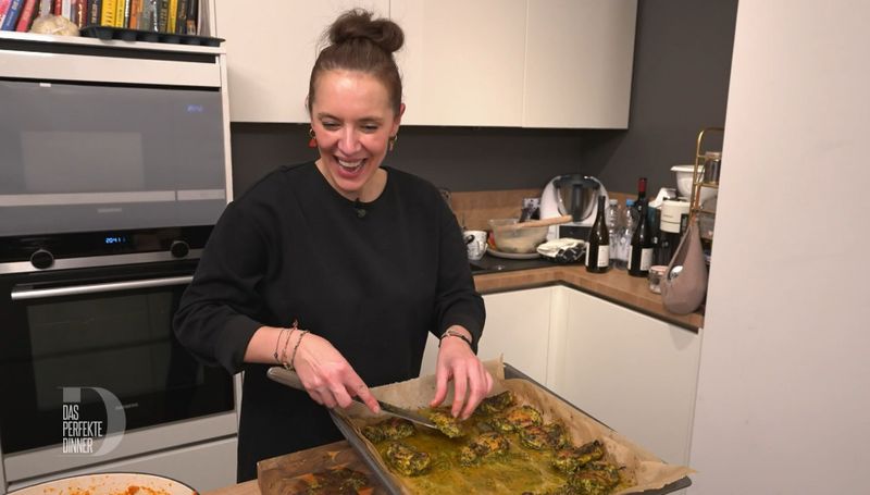 Spaß ist wichtig: Kinga (42) beim fröhlichen Anrichten des Huhns.