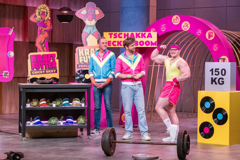 "Der Erfolg eines guten Muskelaufbaus liegt nicht unbedingt im Gym, sondern vielmehr in der Küche", sagt der Schauspieler. Der Bizeps seines Kollegens Roger zieht neidische Blicke auf sich.