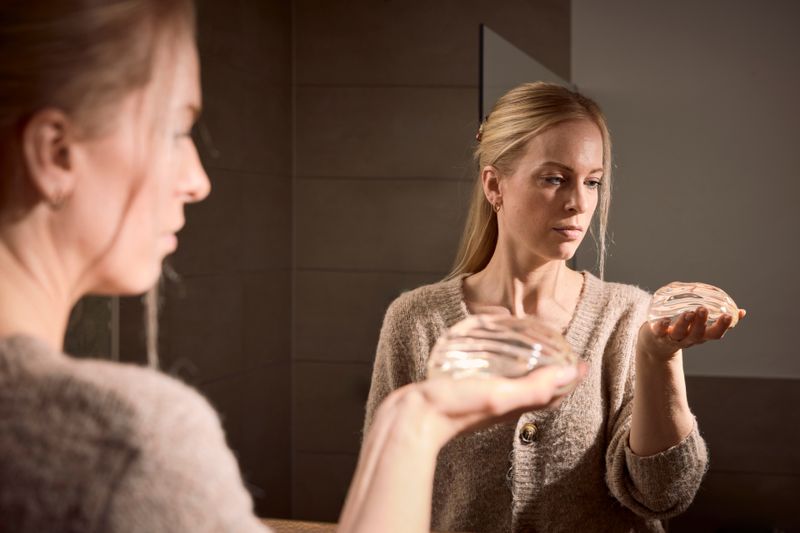 Lauren (36) hält nach zehn Jahren das Implantat in der Hand, das sie lange sehr krank gemacht hatte.
