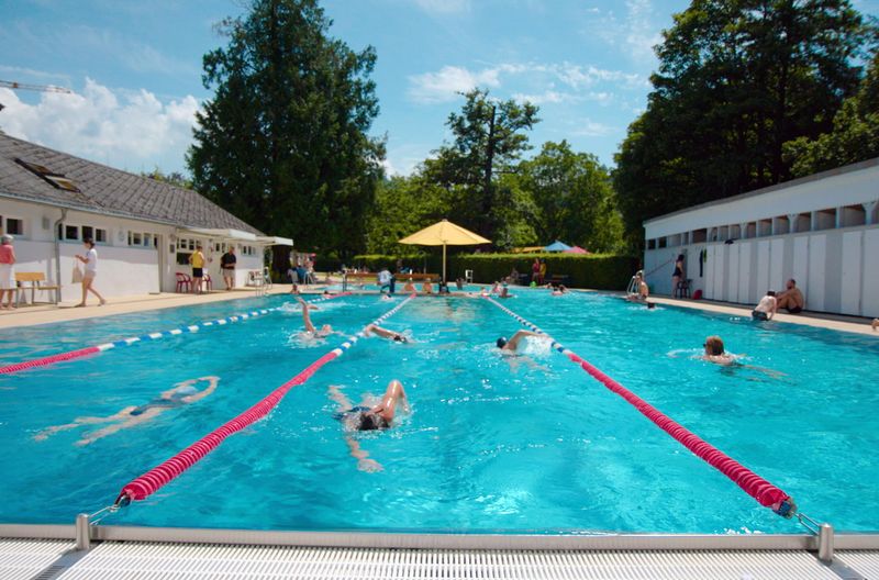 Badegäste schwimmen im Freiburger Lorettobad. Das Bad von 1842 gilt als ältestes Freibad Deutschlands.
