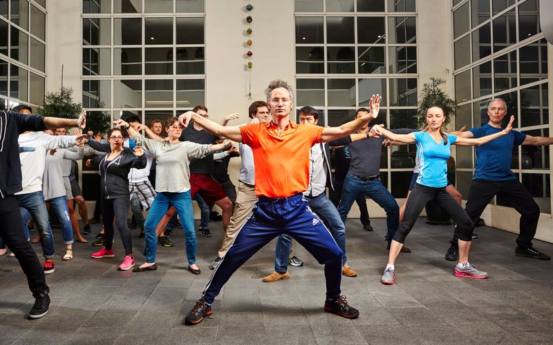 Wer ist dieser Mann? Milliardär Alex Karp, hier im orangenen Shirt, leitet das größte Überwachungsunternehmen der Welt - und gibt seinen Mitarbeitern Tai-Chi-Kurse.