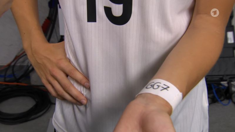 Klara Bühl zeigt den Gruß an ihre Kapitänin, den sie am Handgelenk trägt.