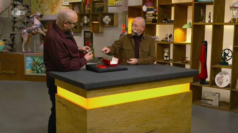 Horst Lichter erkannte die bekannte Marke schon von weitem: "Das ist typisch Cartier." Experte Sven Deutschmanek nickte zustimmend und meinte dazu: "Viele erkennen das auch an der rot- und goldfarbenen Verpackungen." Aktuell gab es wieder einen Hype um kleine Uhren, "auch bei Männern", so Deutschmanek. Da passte dieses Modell eigentlich gut. 