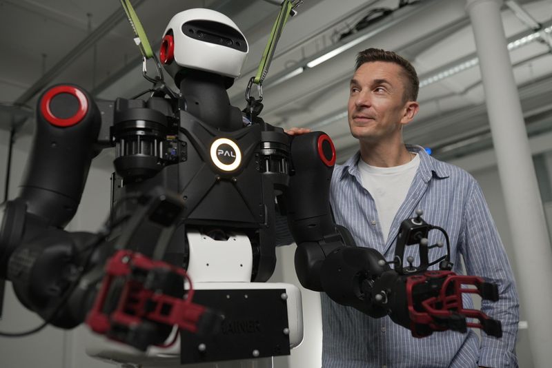 Auf Augenhöhe mit einem Kraftprotz: Eric Mayer prüft einen Roboter, der an der Technischen Universität Darmstadt entwickelt wurde.