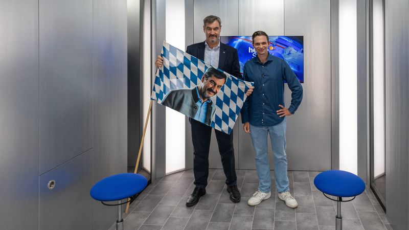 Ein Vier-Augen-Gespräch auf acht Quadratmetern in einem Fahrstuhl: Dem stellen sich Gastgeber Fabian Köster (rechts) und der bayerische Ministerpräsident Markus Söder. 