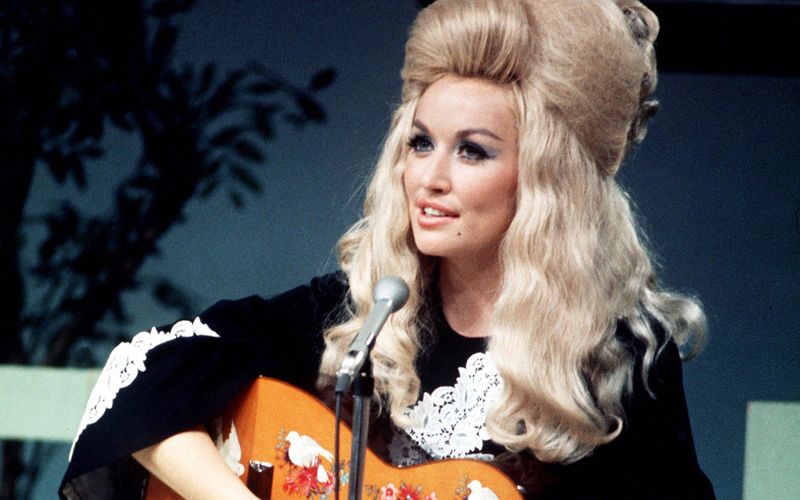 Na, hätten Sie sie erkannt? Auf dem Bild ist Dolly Parton 1970 zu sehen, als sie noch ganz am Anfang ihrer Karriere stand. Inzwischen gehört die US-Musikerin zu den größten Stars im Musikgeschäft. Die Galerie blickt hinter die Fassade aus gigantischen Frisuren und Make-up: Diese 15 Dinge wussten Sie bestimmt noch nicht über Dolly Parton! 