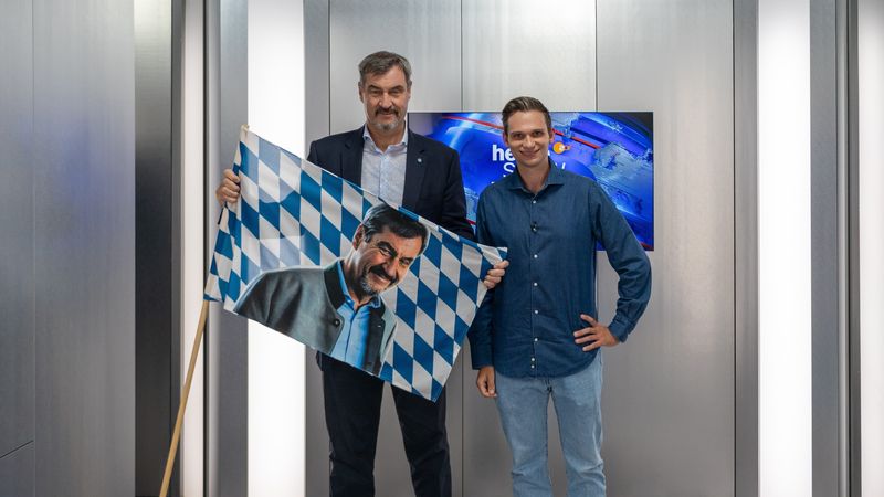 Ein Vier-Augen-Gespräch auf acht Quadratmetern in einem Fahrstuhl: Dem stellen sich Gastgeber Fabian Köster (rechts) und der bayerische Ministerpräsident Markus Söder. 