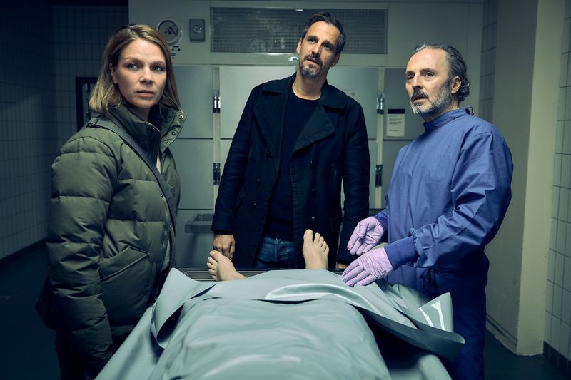 Die Schwarzwald-Kommissare Maris Bächle (Jessica Schwarz) und Konrad Diener (Max von Thun) besprechen mit dem spitzzüngigen Dr. Stefan Zabel (Robert Schupp, rechts) die medizinischen Erkenntnisse zu ihrer neusten Leiche.