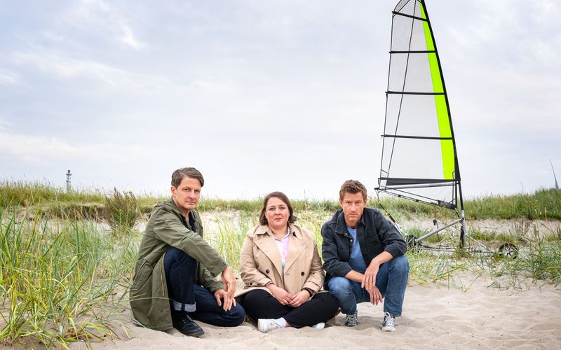 Bestatter Habedank (Holger Stockhaus, links) war gerade mit Melanie Harms (Tina Pfurr) unterwegs und beklagte sich, dass sich sein Schwarm Insa seit ihrem Umzug in die USA noch nicht bei ihm gemeldet hat, da stießen sie auf den tödlich verunglückten Dr. Momsen. Und die Hobbyermittler haben für Polizist Henk (Maxim Mehmet) auch gleich eine Theorie.