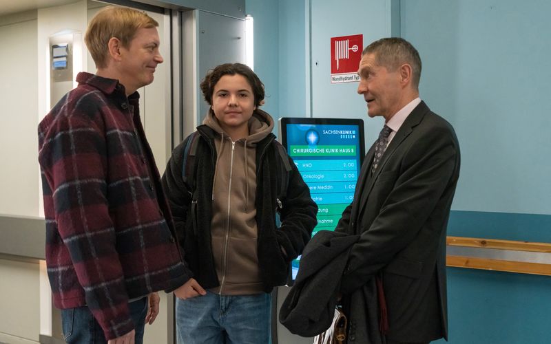 Dr. Rolf Kaminski (Udo Schenk, rechts) freut sich über den Überraschungsbesuch von seinem Sohn Fabian Althaus (Daniel Krauss, links) und Enkel Jack (Franz Hagn) zum Weihnachtsfest.