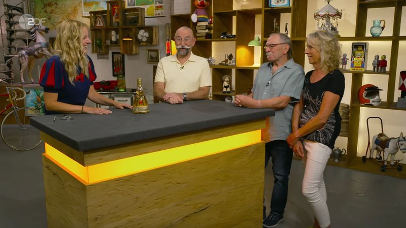 Die Likörflasche mit der tanzenden "kleinen Lady" war für Horst Lichter kein unbekanntes Stück. Er kannte sie aus früheren "Bares für Rares"-Sendungen. Deshalb lag sein Fokus in der Montagsausgabe der ZDF-Trödelshow woanders: Nachdem Expertin Annika Raßbach bestätigt hatte, dass sie sich "auch mit Schnaps auskennt", forderte er eine Verkostung ... 