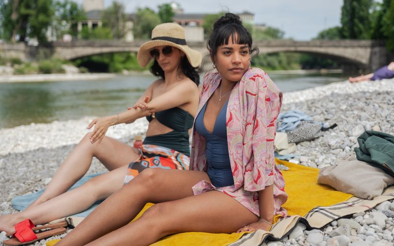 Neben einem klugen Blick auf unsere Gesellschaft bietet "Damen" auch traumhafte Aufnahmen aus dem Sommer in München: Sema (Şafak Şengül, links) und Maya (Salka Weber) sonnen sich wie viele an der Isar. 