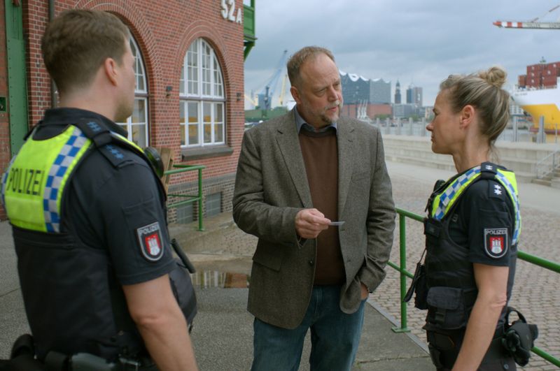 Spediteur Dieter Laube (Smudo, Mitte) soll Franzi (Rhea Harder-Vennewald, rechts) und Nick (Raúl Richter, links) dabei helfen, mehr über den Fahrer Dennis zu erfahren.