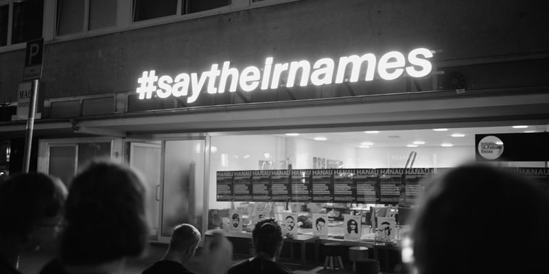 #saytheirnames leuchtet vom Vordach der "Initiative 19. Februar Hanau" und wurde bundesweit zu einem wichtigen Slogan im Kampf gegen Rassismus. 