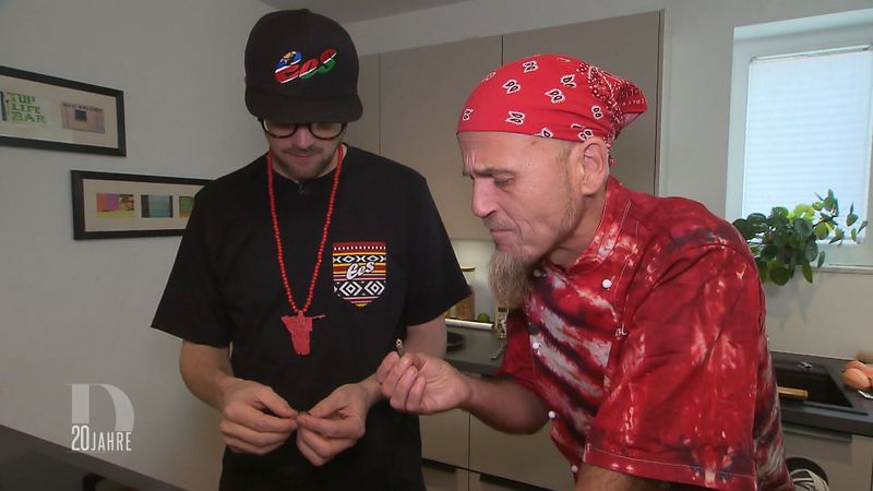 Ralf Zacherl (rechts) taucht überraschend als Schnibbelhilfe bei Ees auf und probiert zum ersten Mal einen Mopanewurm.
