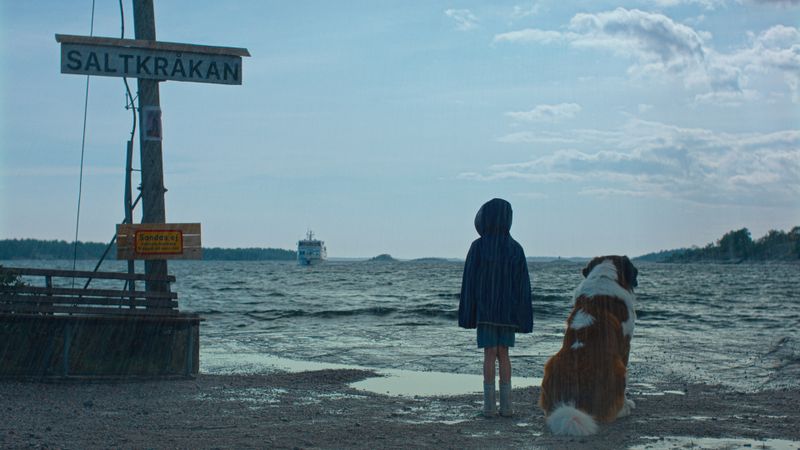 Tjorven (Vega Åhman) und ihr Hund Bootsmann warten gespannt auf die Fähre aus Stockholm. Ob sich an Bord wohl ein paar Kinder befinden? 