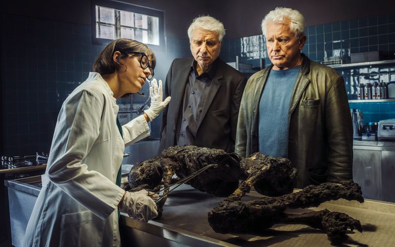 Die Kabarettistin Eva Karl Faltermeier schlüpft zum "Tatort"-Anschied von Kriminalhauptkommissar Franz Leitmayr (Udo Wachtveitl, Mitte) und Kriminalhauptkommissar Ivo Batic (Miroslav Nemec) in die Gastrolle der Rechtsmedizinerin Dr. Roswitha Schwarz-Fischer.