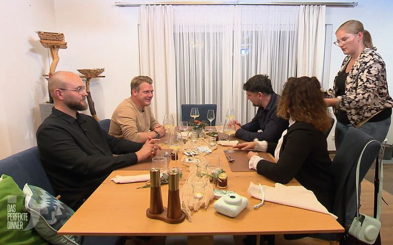 Carinas Gäste können nicht verstehen, was ihr Mann an ihrer Kochkunst auszusetzen hat.