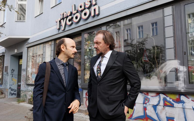 Michael (Charly Hübner, rechts) ist der Besitzer einer hoch verschuldeten Videothek, den der Journalist (Leon Ullrich) zu einem Helden stilisieren will. 