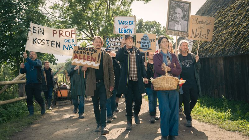 Unter Leitung von Sunna Schulz (Katinka Auberger, zweite von rechts) demonstriert eine Gruppe von Bürgern für den Schutz des Trinkwassers. 
