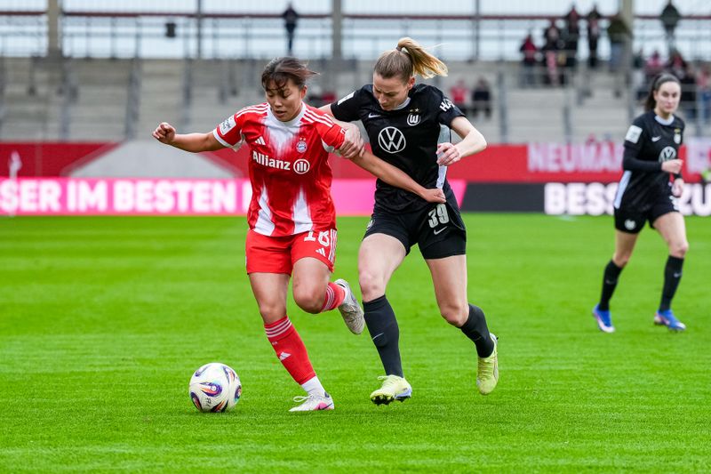 Momoko Tanikawa von Bayern München and Sarai Linder vom VFL Wolfsburg kämpfen im Spiel des Ligavergleichs um den Ball. Auswärts in Wolfsburg gewann Bayern am 11. Oktober 2025 mit 3:1. Das Rückspiel in München entschied Bayern klar für sich - am 22. Februar 2026 mit 4:1.